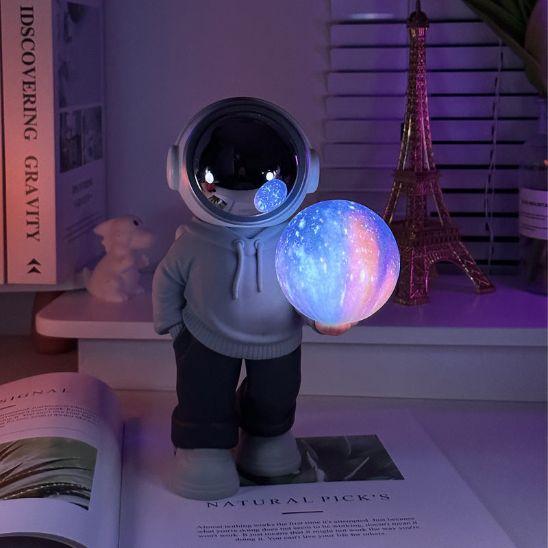 Holding the dreamy starry sky (grey top + navy blue pants) Creative Astronaut Bluetooth Speaker with 3D Starry Sky Lighting, Portable Wireless Moon Lamp Speaker – Perfect Gift for Space Enthusiasts